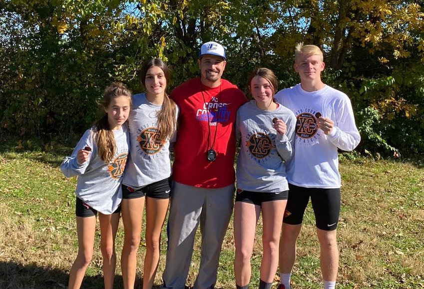 THE STATE BOUND runners from the Clinton XC team are: Leah Kenney, Vyla Brown, Alexa McCartney and Gage Mantonya with their proud coach, Nathan Johnson.