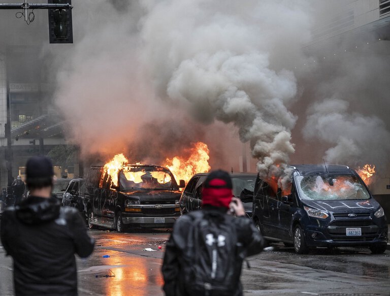 Protesters set fire May 30 to vehicles on Sixth Avenue in downtown Seattle. A judge has ordered The Seattle Times and four other media outlets to comply with a subpoena to turn over unpublished photos and videos. (Dean Rutz / The Seattle Times)