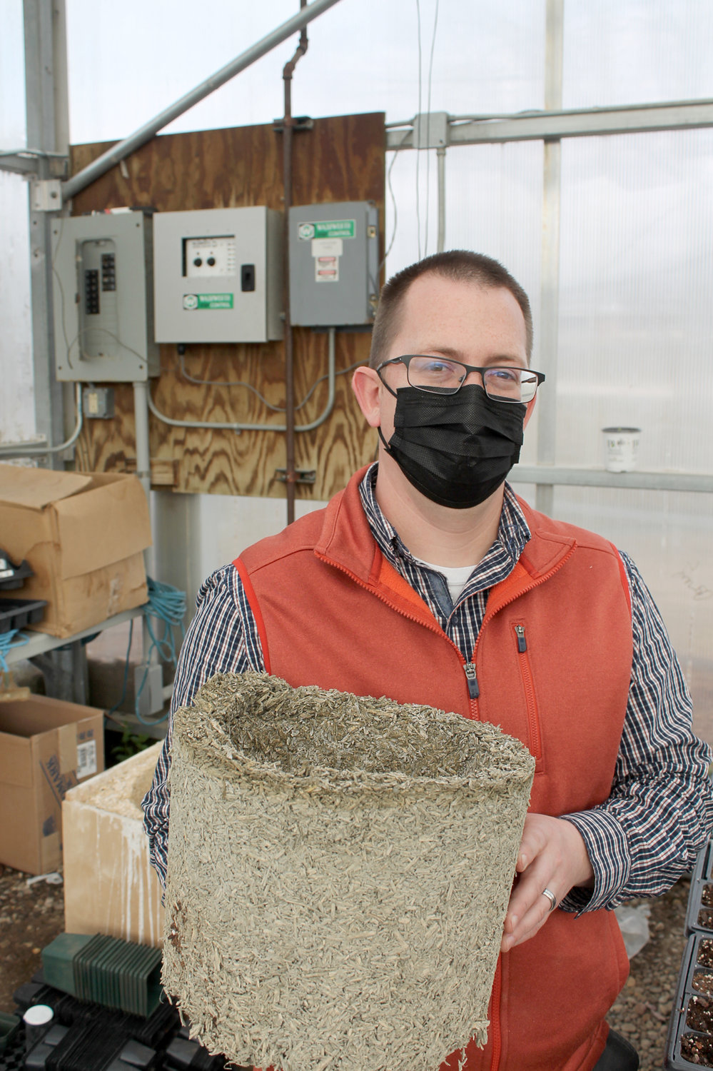 Muscatine Community College agriculture teacher Shane Mairet displays one of the products made by the first Iowa hemp class: A container each member of the class created from hemp, water and chemical lime.