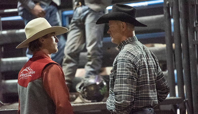 NWC assistant coach Dan Mortensen (right) talks with Austin Herrera after his bull ride last month during the Trapper Stampede Rodeo in Cody. Mortensen is a six-time world champion in saddle bronc, a one-time world champion in all-around and a ProRodeo Hall of Fame member.