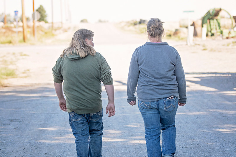 Tag Thompson and his mother, Maria Berchtold, walk down the county road at Thompson Farms.