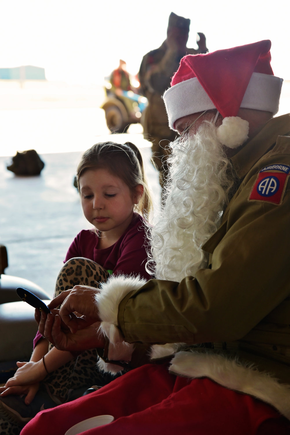 Eight-year-old Georgia Davis came from Texas to watch her daddy jump from an airplane. Here she is pictured with Santa, learning about WWII.