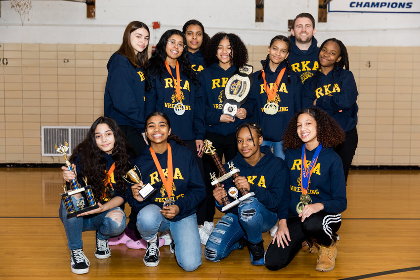 Riverdale/Kingsbridge Academy wrestling coach Michael Lepetit poses with some of his girls that have helped make the Tigers&rsquo; middle and high school wrestling teams so successful.