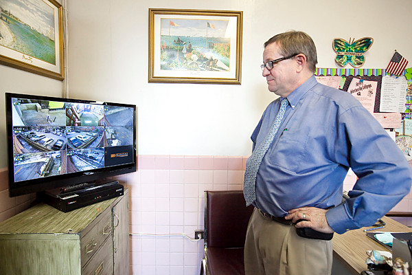 Jayson Bock, principal at St. John’s School looks at the flat screen security monitor on Monday. The security system, called Digital Watch Dog, allows him to view the system from his office computer as well as from his smartphone.