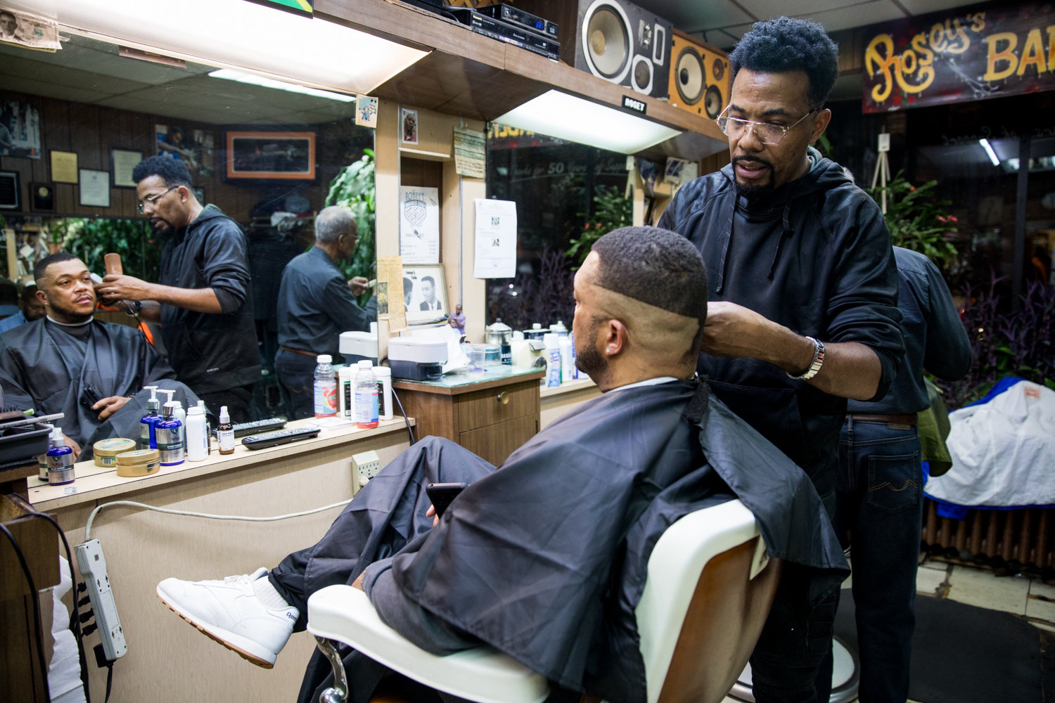 Garfield Myrie gives a haircut to Joe White at Marble Hill’s International Unisex Salon. White travels to the salon every two weeks from Washington.