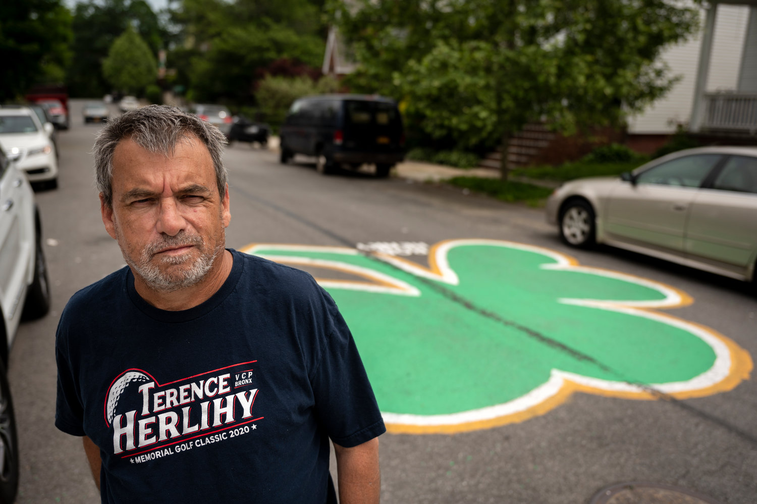 Pat Connaire poses for a portrait near the clover he painted at the intersection of West 260th St and Delafield Ave to honor two recently deceased Bronxites.