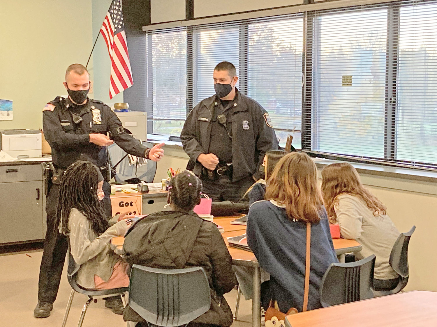 STUDYING THE EVIDENCE — A group of Strough Middle School seventh-graders discuss the findings of their classroom investigation with school resource officers recently. The activity was designed to help students learn about law enforcers and develop positive relationships in a fun learning environment.