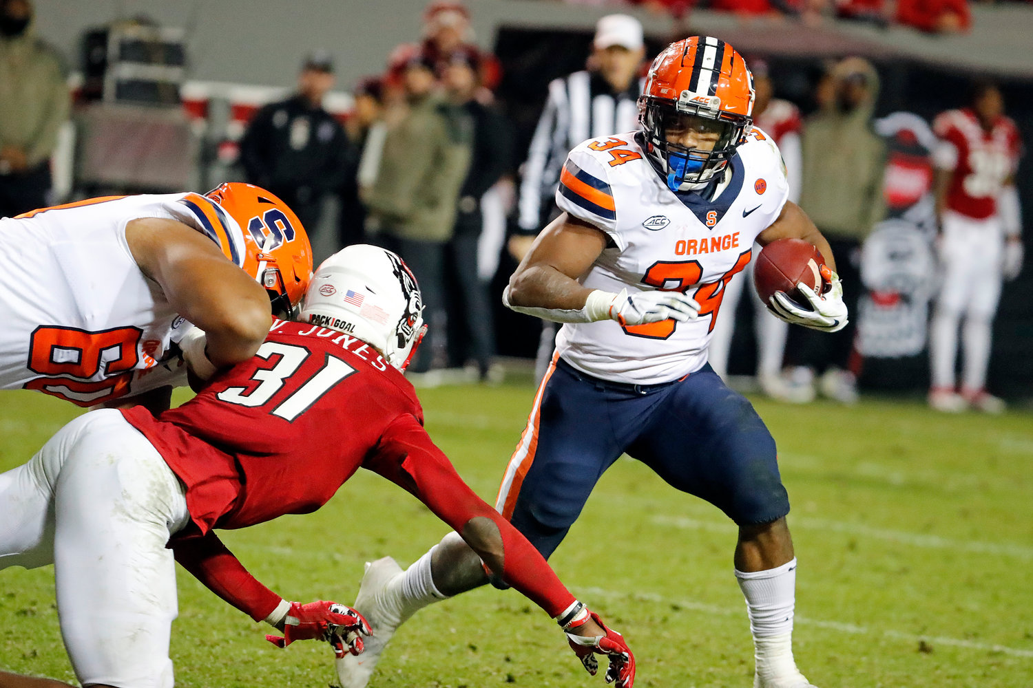 SINGLE-SEASON RUSHING LEADER — Syracuse's Sean Tucker (34) runs the ball away from North Carolina State's Vi Jones (31) during the second half of an NCAA college football game in Raleigh, N.C., Saturday, Nov. 20. The Orange lost to the Wolfpack, 41-17.