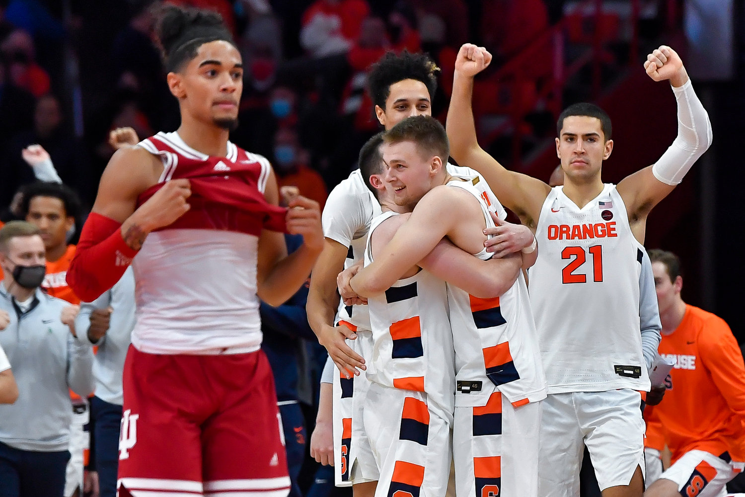 DOUBLE OVERTIME THRILLER — Syracuse guard Buddy Boeheim, center, hugs guard Joe Girard as forward Cole Swider (21) celebrates their win as Indiana guard Khristian Lander, left, walks to his bench after a college basketball game in Syracuse on Tuesday night. Syracuse won 112-110 in double overtime.