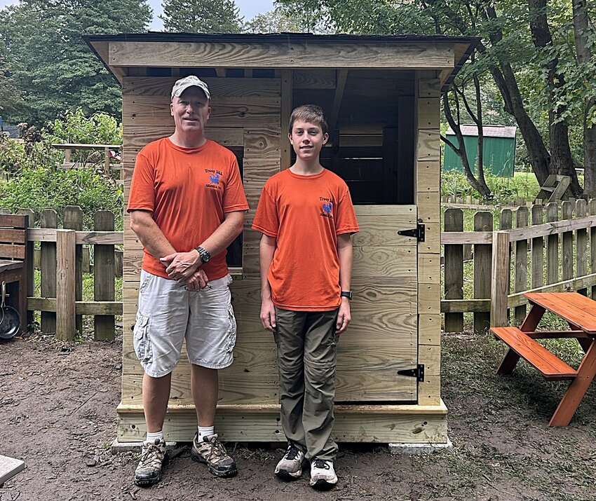 Nicholas Tubiolo (right) and Jason Jackson stood in front of the cabin and picnic table after the project was completed.